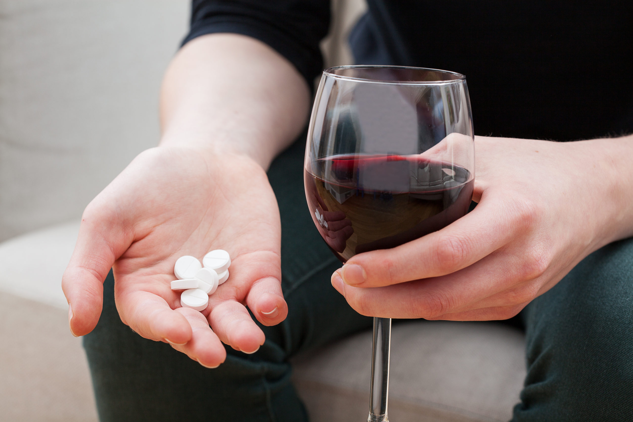 Medikamente bei Alkoholentgiftung: Mann mit Tabletten und Wein